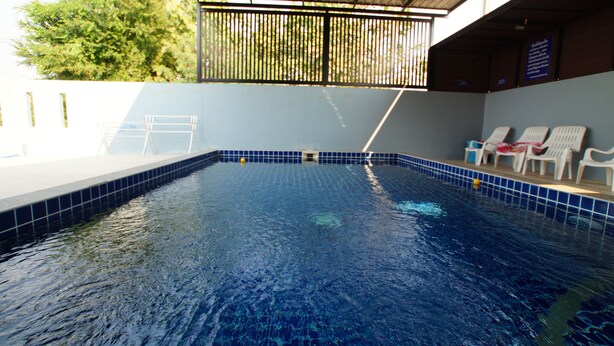 An indoor swimming pool with clear blue water, a tiled edge, and a few lounge chairs. - Baan Samart 1 Pool Villa Hua Hin (Hua Hin)