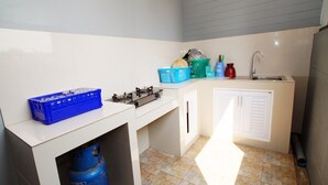 A compact kitchen with a gas stove, sink, and storage cabinets. - Baan Samart 2 Pool Villa Hua Hin (Hua Hin)
