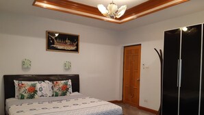 A bedroom with a bed, a wardrobe, a door, and a chandelier. - Baan Sudrak Pool Villa Hua Hin (Hua Hin)