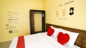 A neatly made bed with white bedding and two red heart-shaped pillows, a wooden headboard, and a wall with a family-themed poster and a mirror. - Baan Tachcha Pool Villa Hua Hin (Hua Hin)