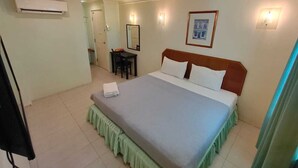 A hotel room with a bed, a desk, a chair, and a mirror. - Johan Travellers Lodge (Malacca City)