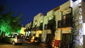 A hotel with a sign reading "ANOLYA HOTEL" and a parked car in front. - Manolya Hotel (Bodrum)