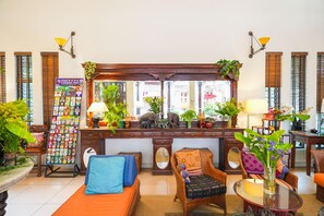 A traditional room with a wooden desk, two chairs, a sofa, and a mirror. - Baan Klang Wiang Boutique Hotel Chiang Mai (Chiang Mai)