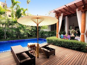 A wooden deck with a pool, lounge chairs, and an umbrella. - Baan Klang Wiang Boutique Hotel Chiang Mai (Chiang Mai)