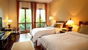 A hotel room with two beds, a desk, a television, and a window with curtains. - Baan Klang Wiang Boutique Hotel Chiang Mai (Chiang Mai)