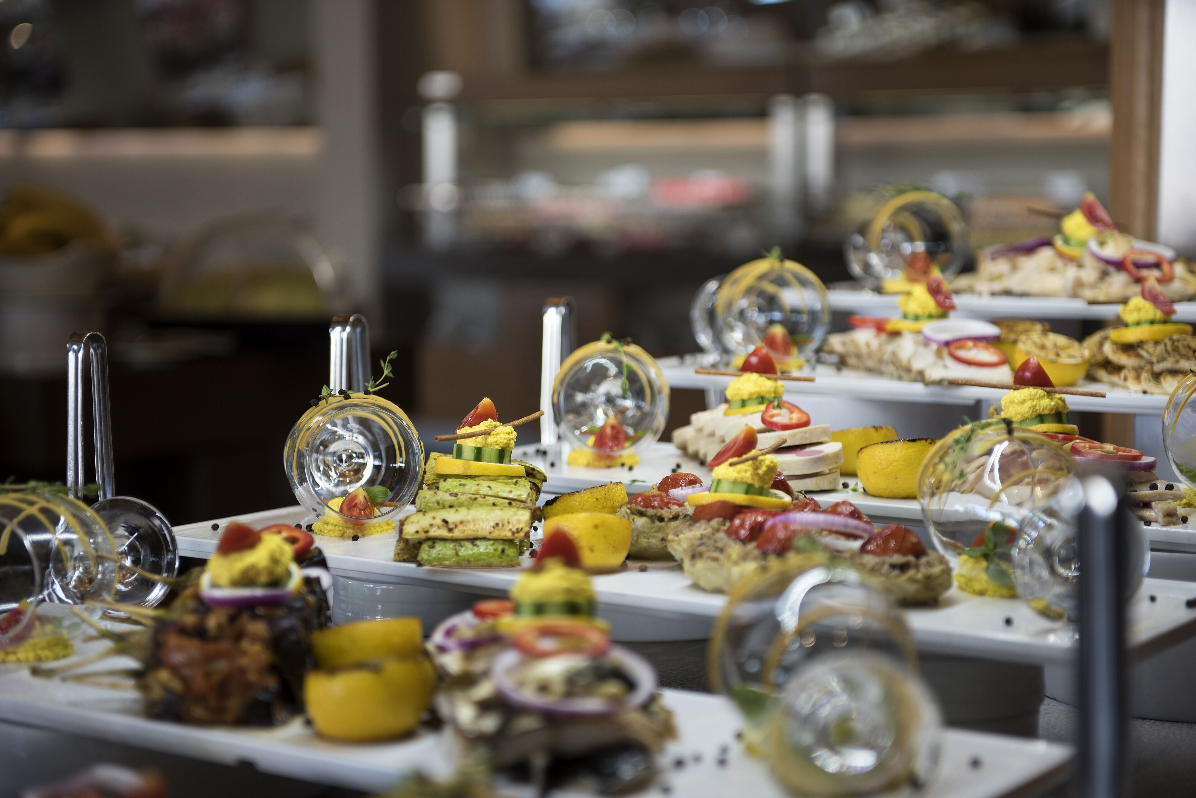 A buffet with various dishes arranged on white trays.
