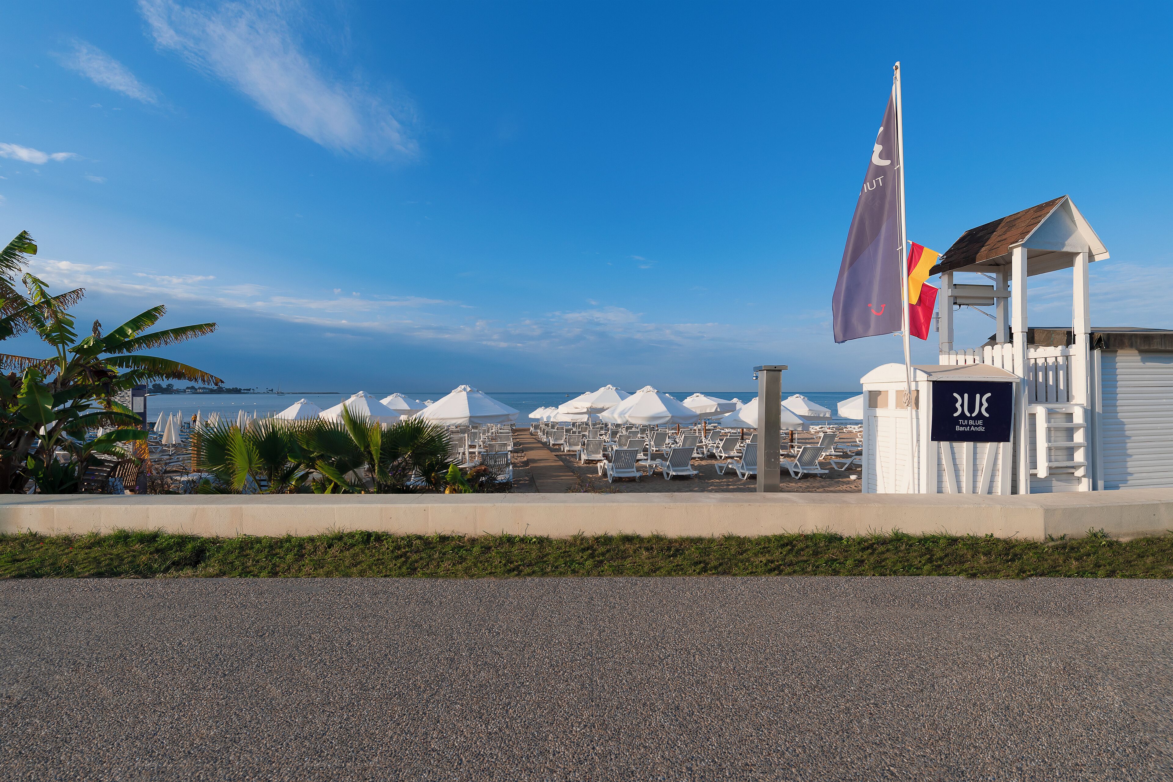 A beachside hotel with a sign reading "Blue Lagoon" and a flagpole with flags.