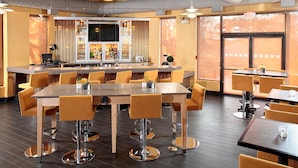 A restaurant with high tables and chairs, a bar area, and large windows. - Doubletree by Hilton Wilkes-barre (Wilkes-Barre)