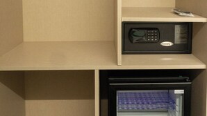Ein kompaktes Zimmer, ausgestattet mit einem integrierten Kühlschrank, einer Mikrowelle und einem kleinen Gefrierfach.