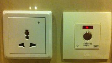 Two electrical outlets and a control panel with a red light and a dial.