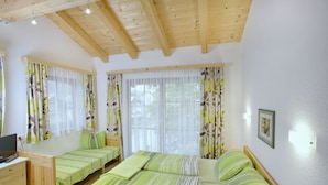 A bedroom with two single beds, a desk with a laptop, and a window with curtains. - Haus Seifriedsberger (Bramberg am Wildkogel)
