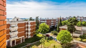 A residential area with brick buildings, green spaces, and a clear blue sky. - Apartment Palcic (Zadar)