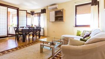 A living room with a sofa, a dining table with chairs, and a coffee table.
