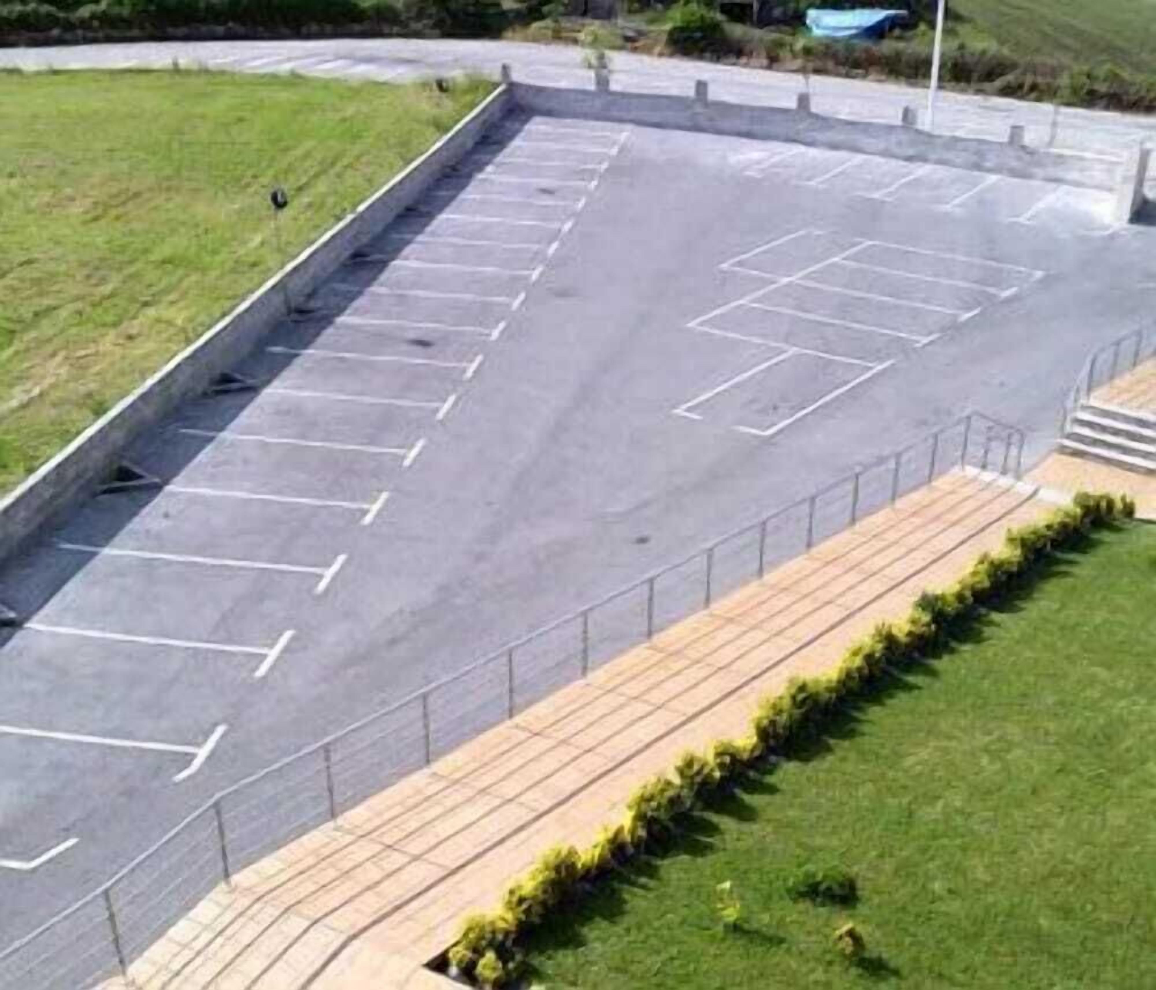 Un estacionamiento con espacios delimitados y una acera para peatones.