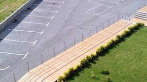 A parking lot with marked spaces and a pedestrian walkway.