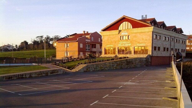 A hotel with a red roof, a reception area, and a parking lot.