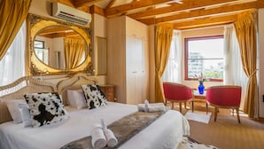 A hotel room with a large bed, a mirror, a desk, and a chair. - Stadium Guest House (Cape Town)