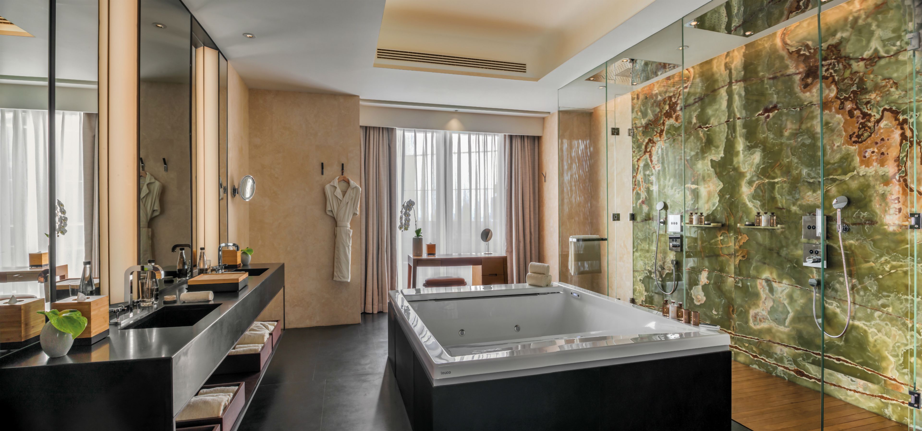 A modern bathroom with a large bathtub, a glass shower enclosure, and a vanity with a mirror.