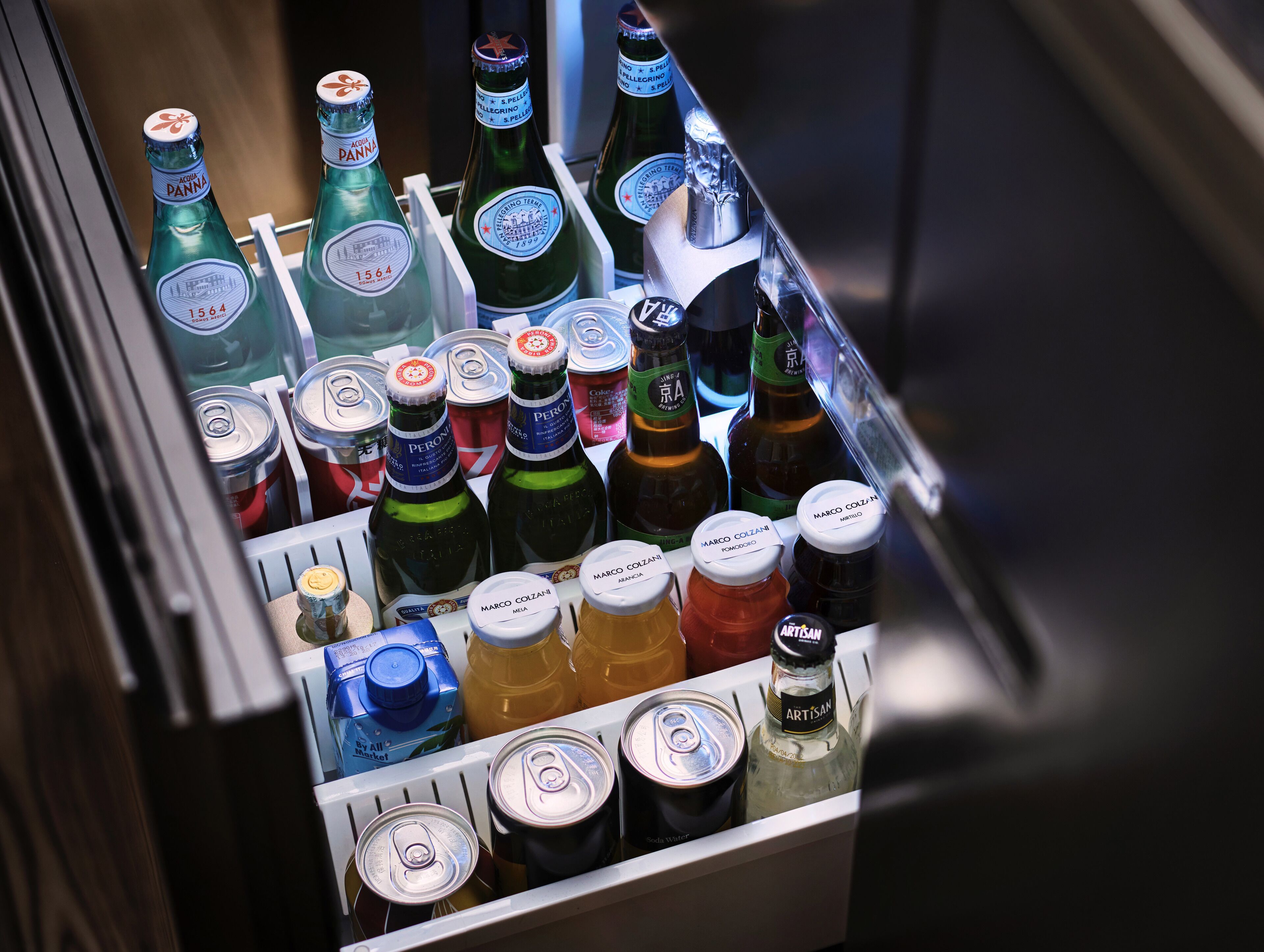 A refrigerator stocked with various beverages including bottles and cans.