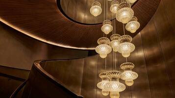 Un interior moderno con una estructura metálica curvada y varias luces esféricas colgantes.