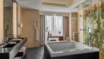 A modern bathroom with a large bathtub, a double sink vanity, and a mirror.