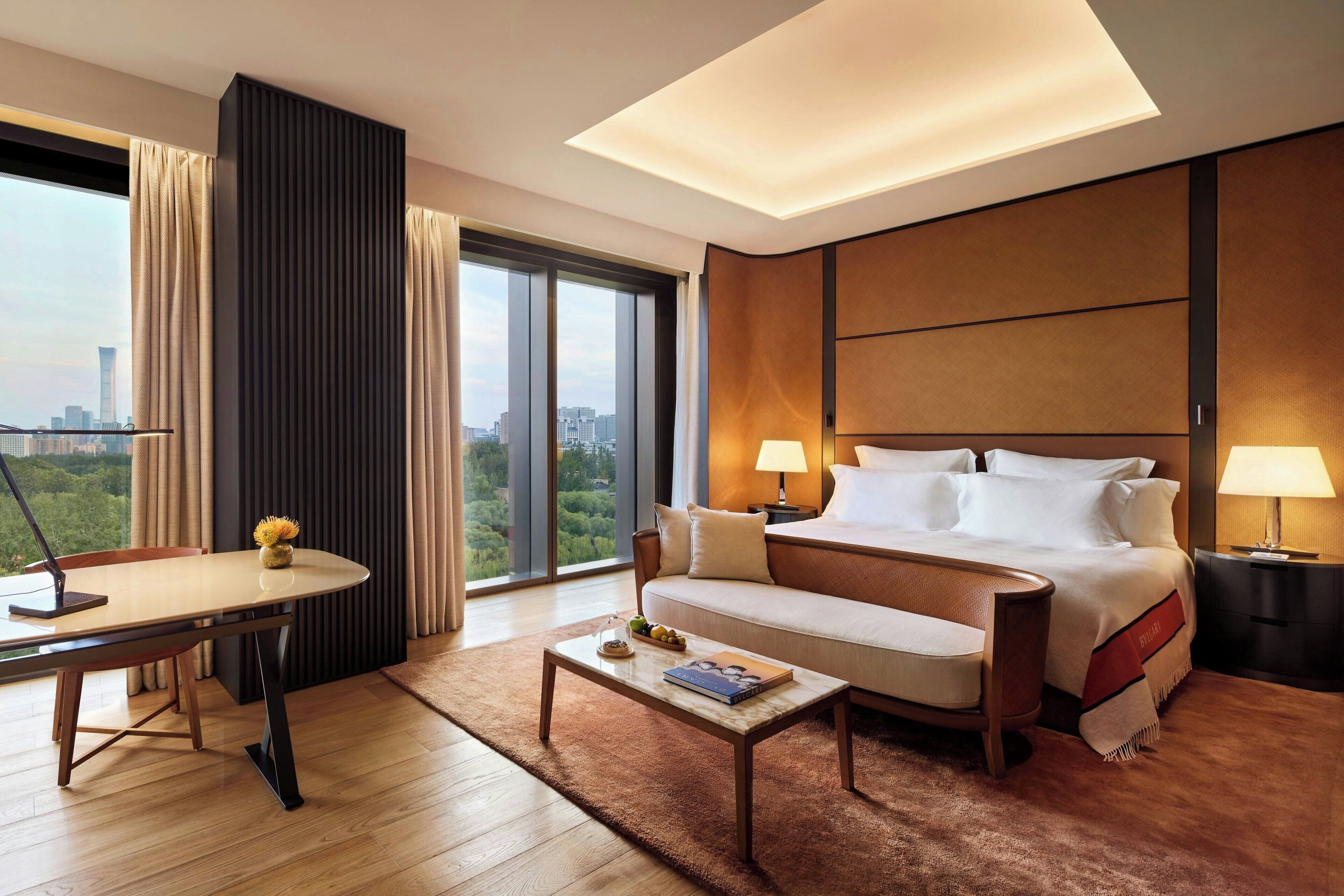Une chambre d’hôtel moderne, dotée d’un grand lit, d’un canapé, d’un bureau et offrant une vue sur la ville.