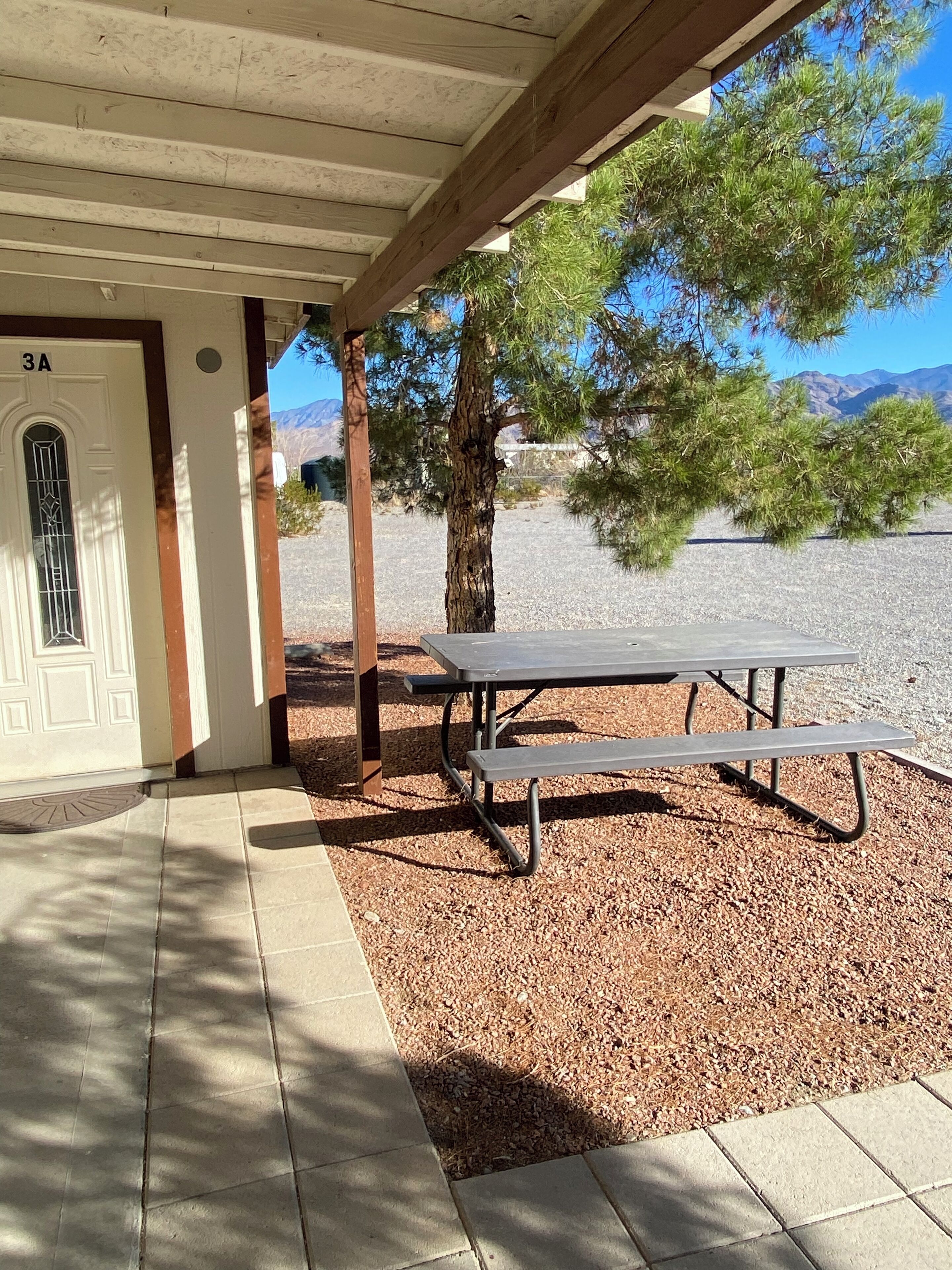 A covered outdoor area with a picnic table and a door labeled "3A".