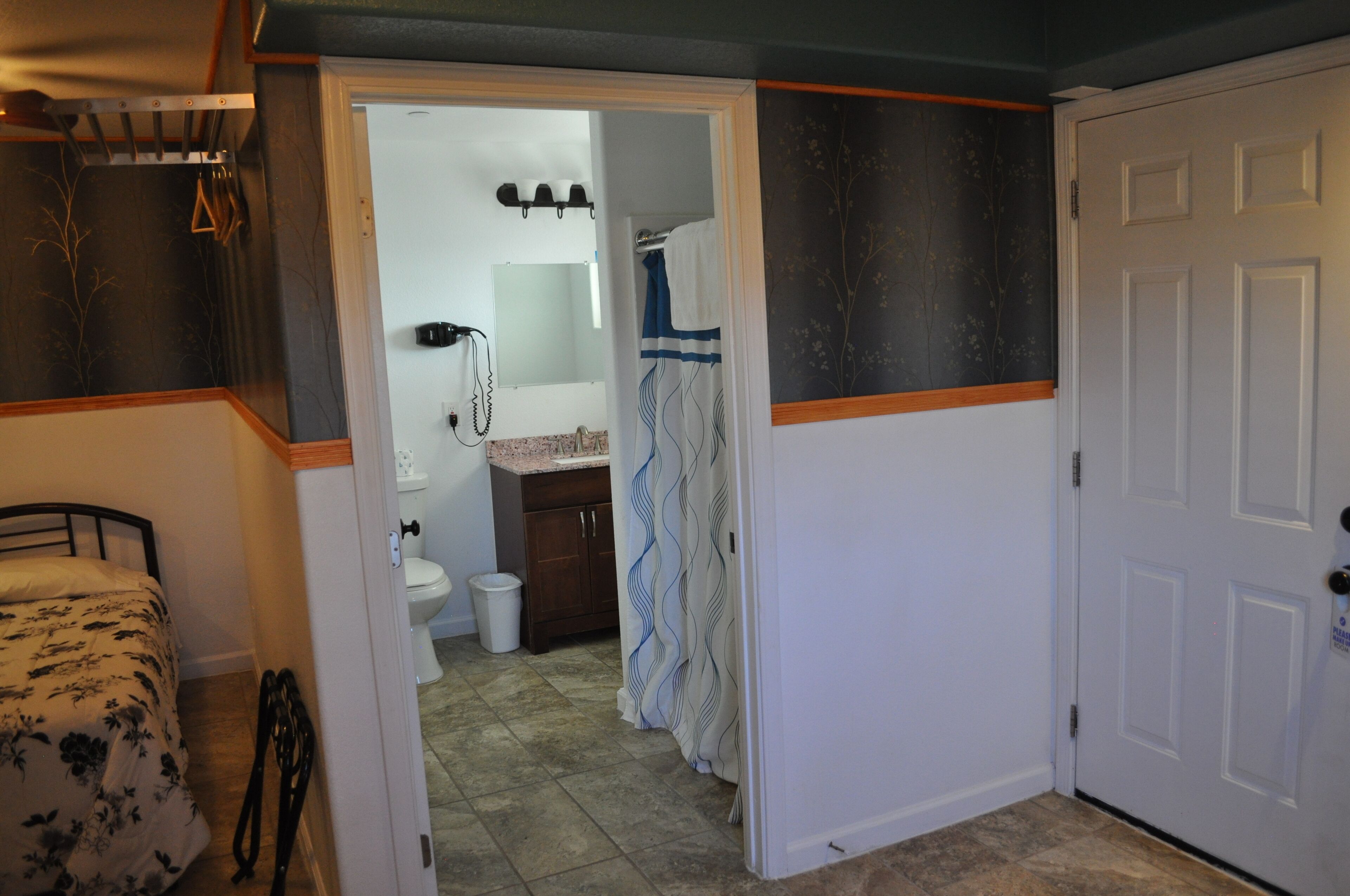 Een slaapkamer met een bed, een badkamer met toilet en een douche.