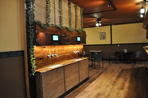 A bar area with wooden counter and multiple taps, surrounded by chairs and tables. - K7 Bed and Breakfast (Pahrump)