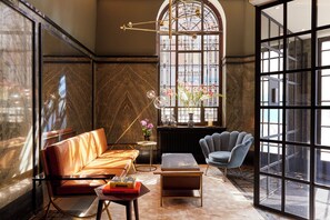 A modern interior with a leather sofa, a round table, and a chair. - Hotel Indigo The Hague - Palace Noordeinde by IHG (The Hague)
