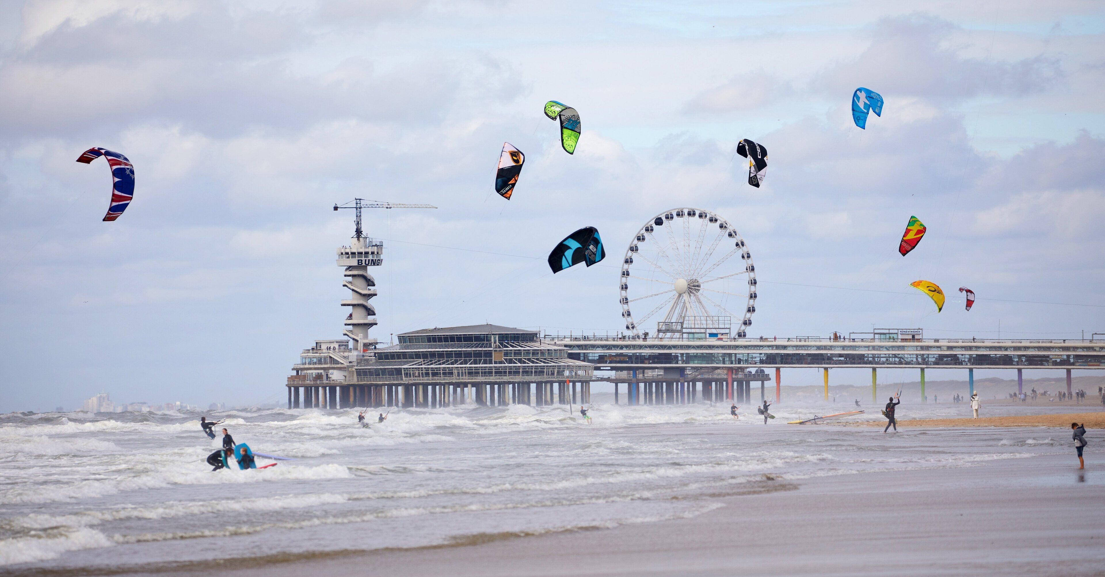 A pier with a Ferris wheel and a control tower.