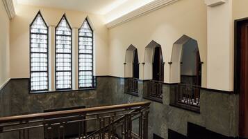 A grand staircase with a wooden handrail and a checkered floor pattern.