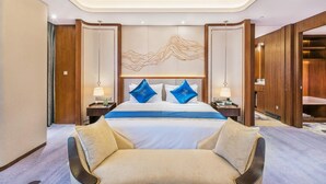 A modern hotel room with a large bed, two nightstands, a desk, and a chair. - Jinling Shihu Garden Hotel Suzhou (Suzhou)