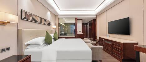 A modern hotel room with a large bed, a TV, a wooden dresser, and a mirror.