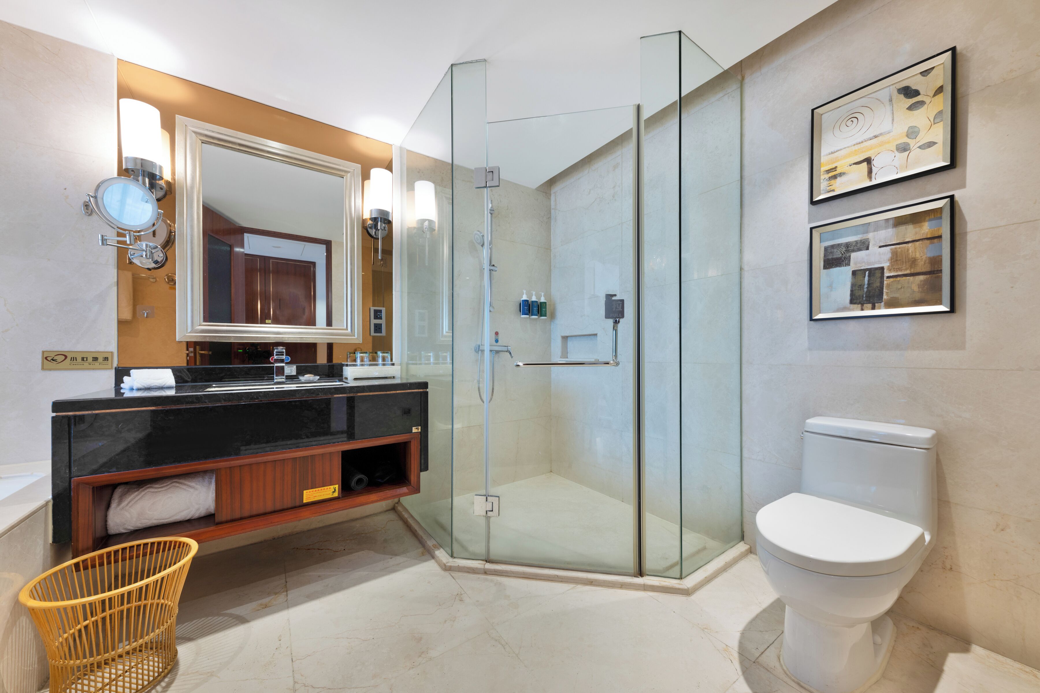 A modern bathroom with a glass-enclosed shower, a large mirror, and a white toilet.