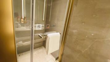 Bathroom with a glass door, towel rack, and caution sign.