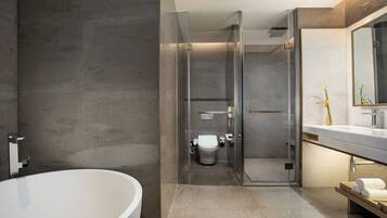 Un baño moderno con una bañera independiente, una ducha con cerramiento de vidrio y un tocador con espejo.