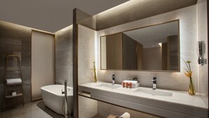 A modern bathroom with a freestanding bathtub, a large mirror, and a vanity with a sink.