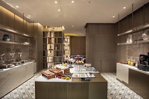 A modern hotel room with a breakfast buffet, a seating area, and a minibar. - Crowne Plaza Fuzhou South by IHG (Fuzhou)