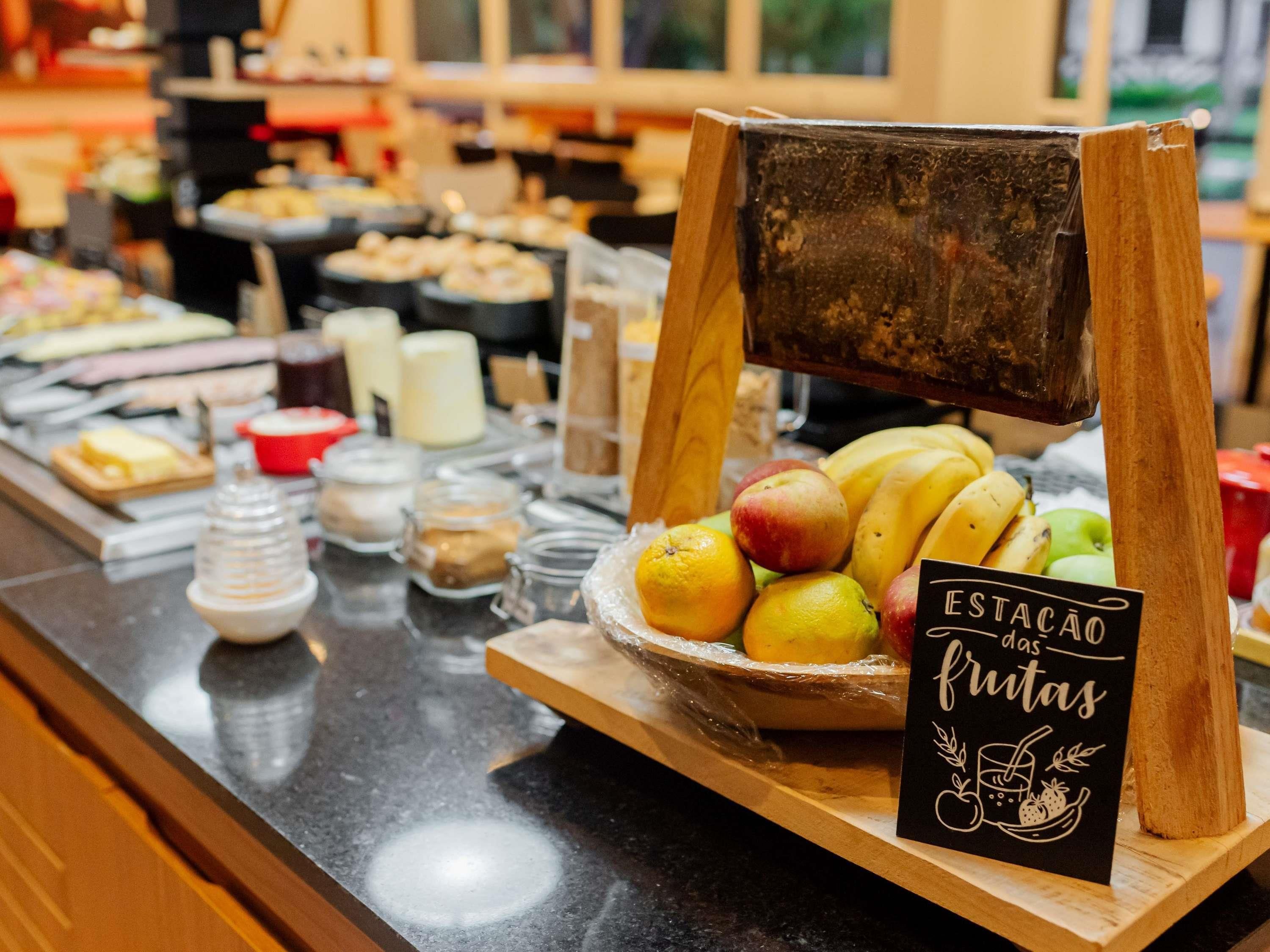 A buffet counter with a variety of food items and a sign indicating the section for fruits.