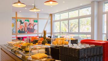 Un buffet proposant une variété de plats, une vitrine transparente et une fenêtre donnant sur un espace verdoyant.