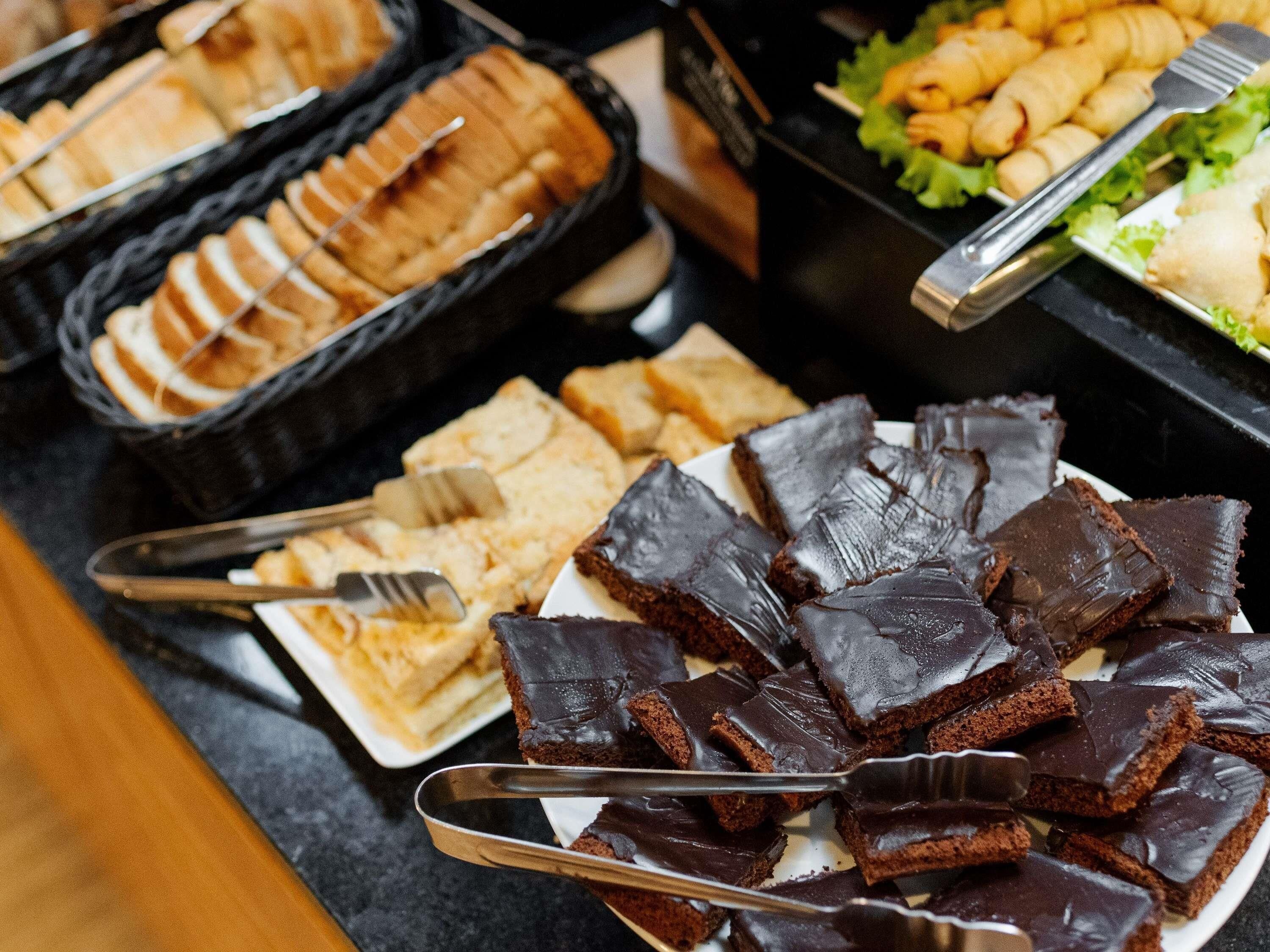 Een buffet met diverse gerechten, waaronder chocoladebrownies en brood.