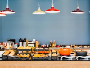 A buffet setup with various food items and a cooking station. - ibis Igrejinha (Igrejinha)