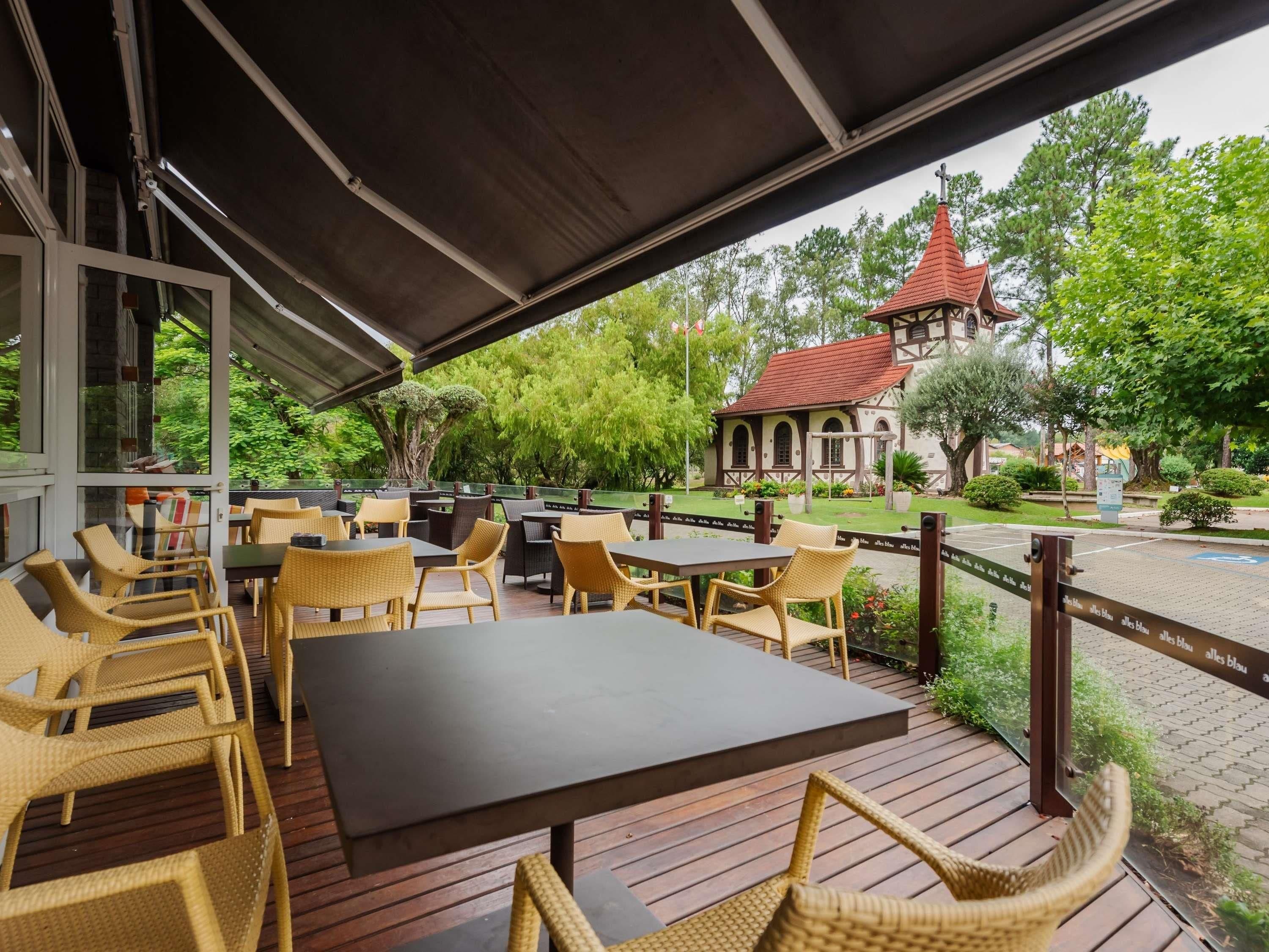 An outdoor seating area with wicker furniture and a view of a building with a red roof.