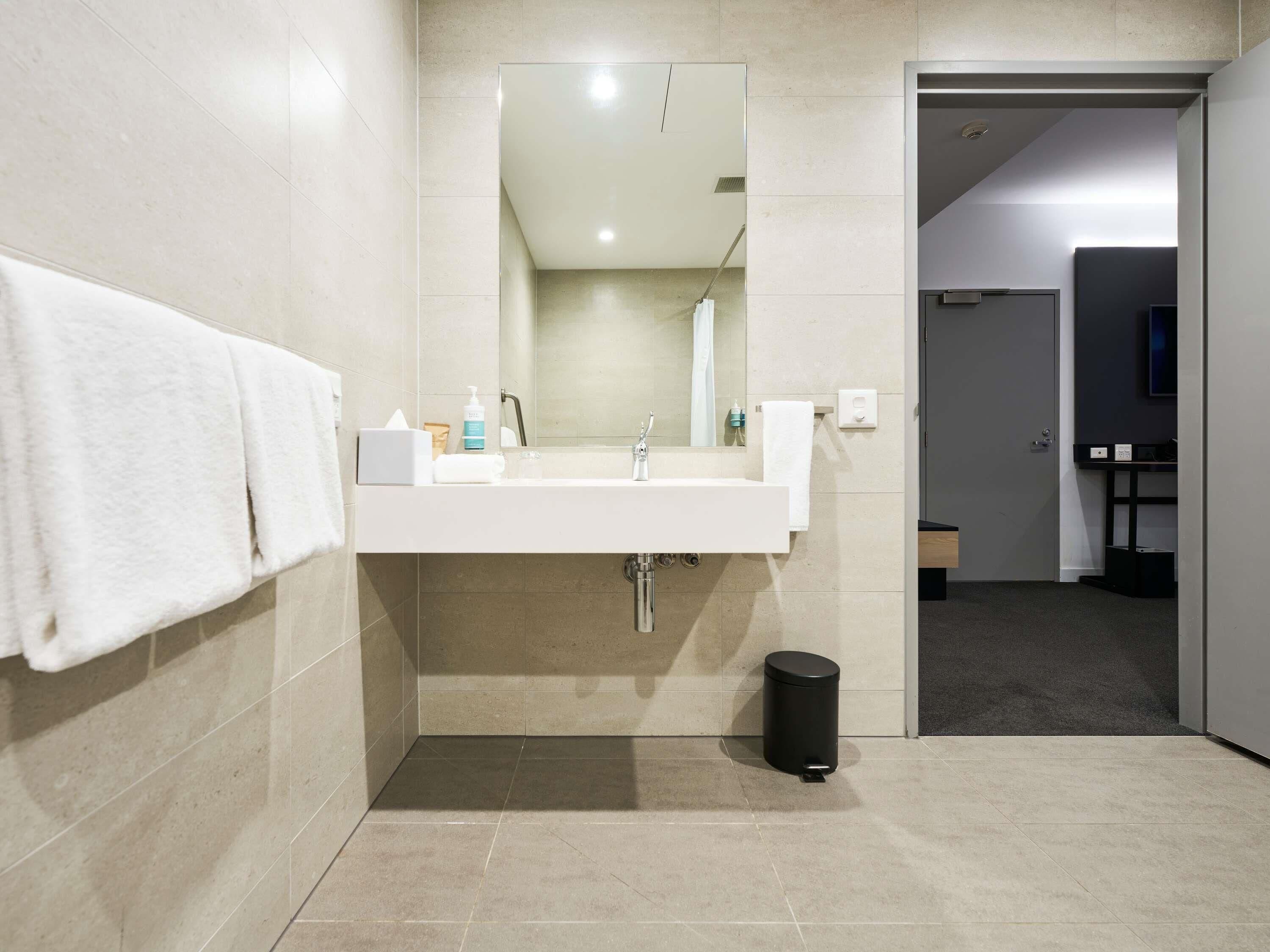 A modern bathroom with a sink, mirror, and toilet.