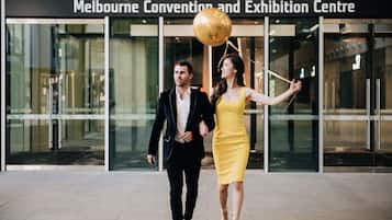 A couple walking in front of the Melbourne Convention and Exhibition Centre.