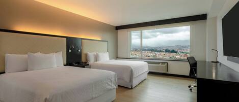 A hotel room with two beds, a desk, a chair, a large window with a city view, and a modern design.