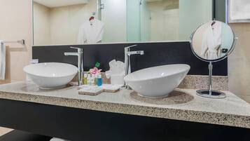 A bathroom with two sinks, a mirror, and a towel rack.