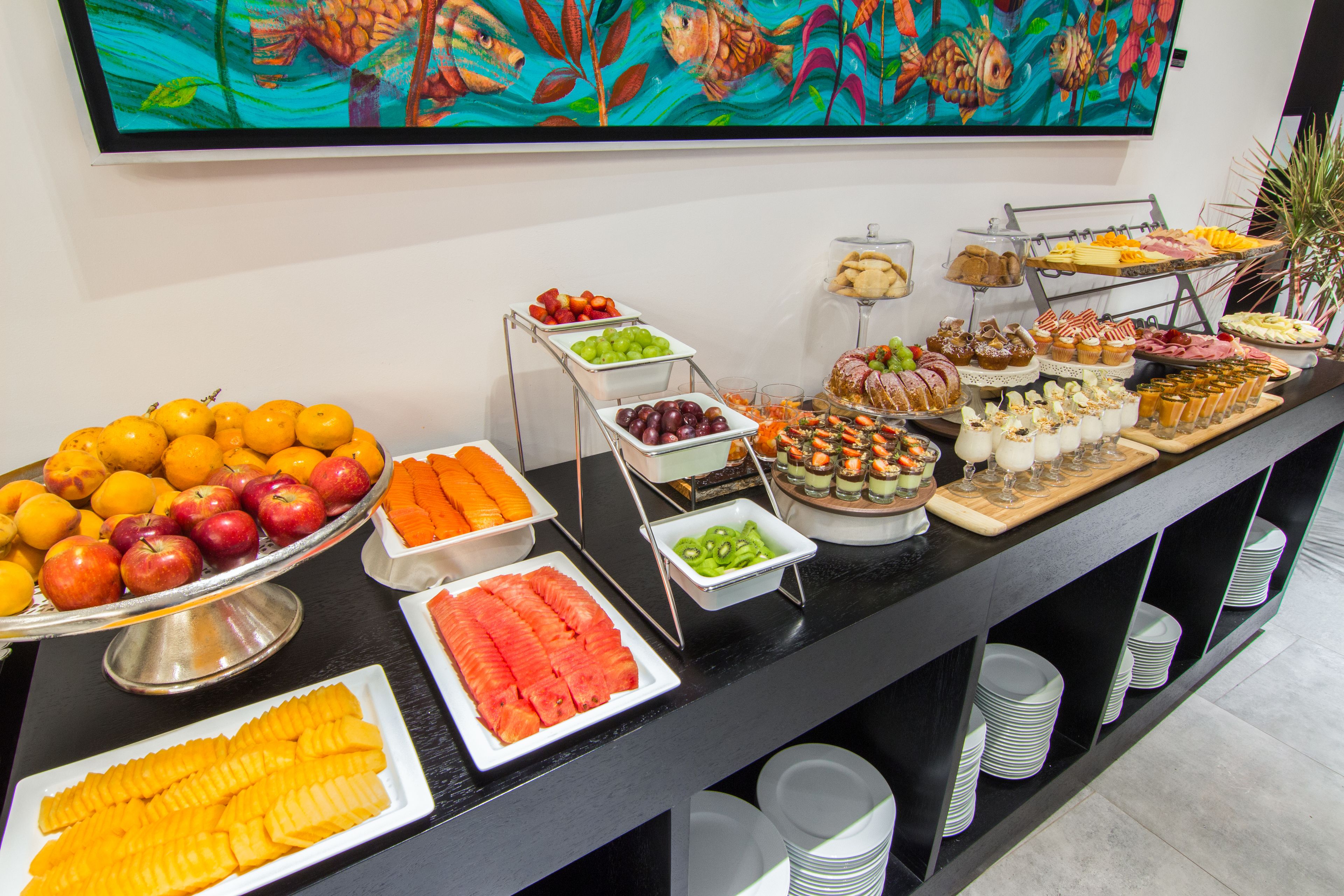 Een buffet met verschillende soorten fruit, groenten en desserts.