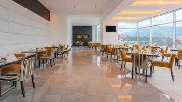A spacious dining area with modern furnishings and a city view.